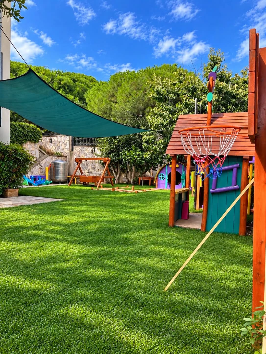 Gölgelikli bahçede oyun evi ve basket potası